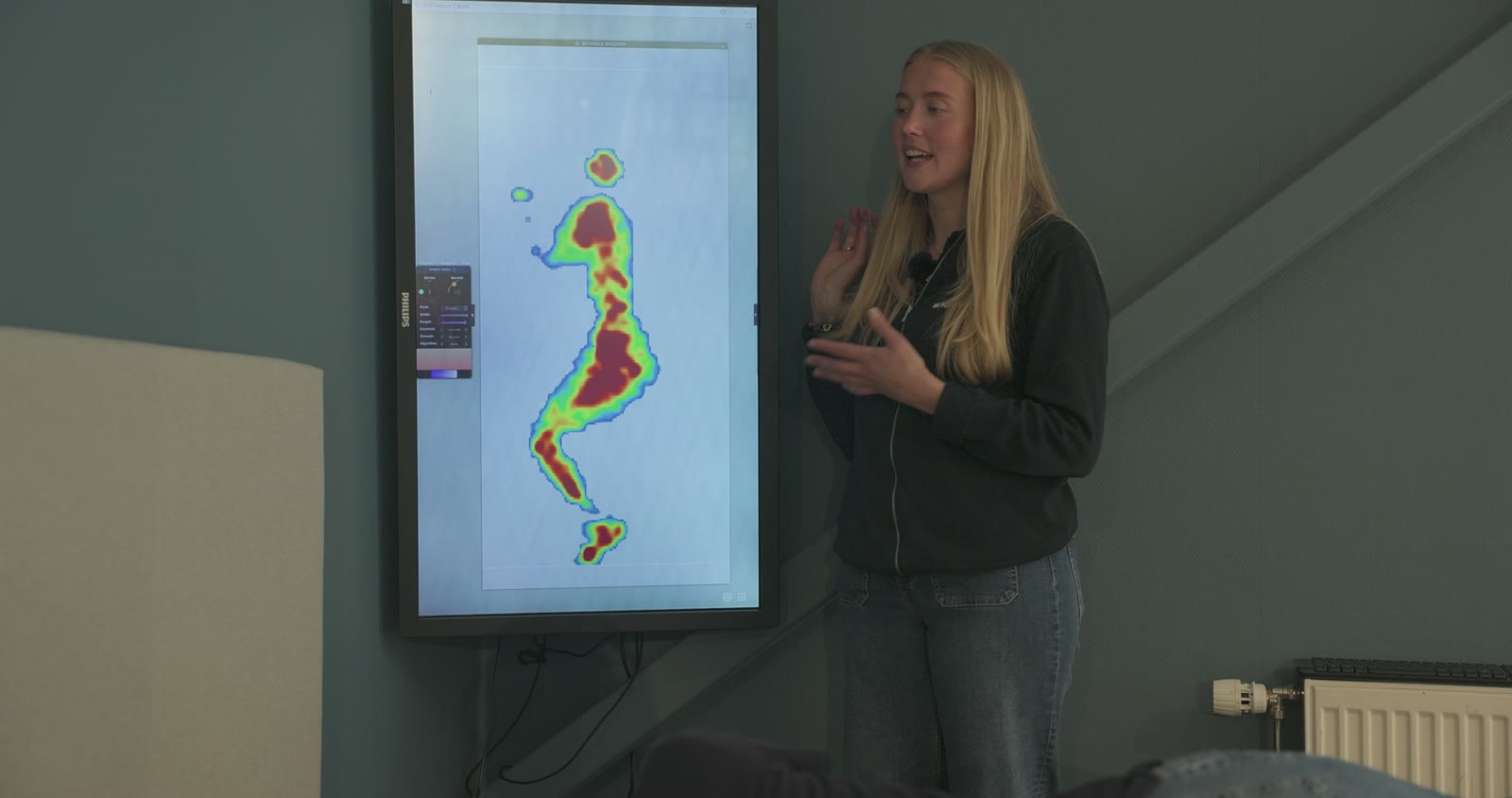 Presenter explaining a body pressure map on screen