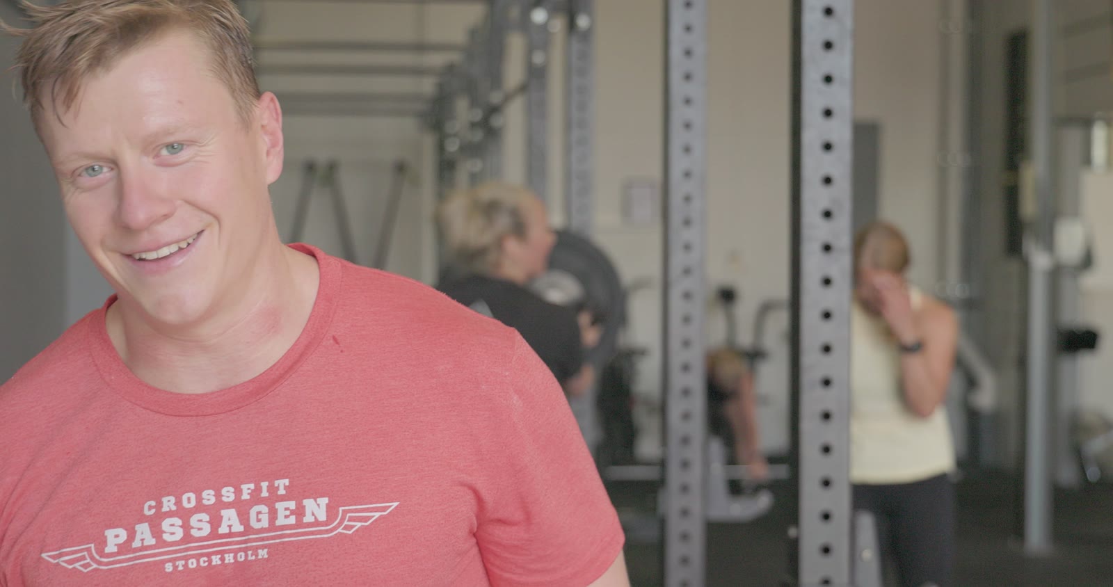 Smiling gym member in a Crossfit Passagen shirt